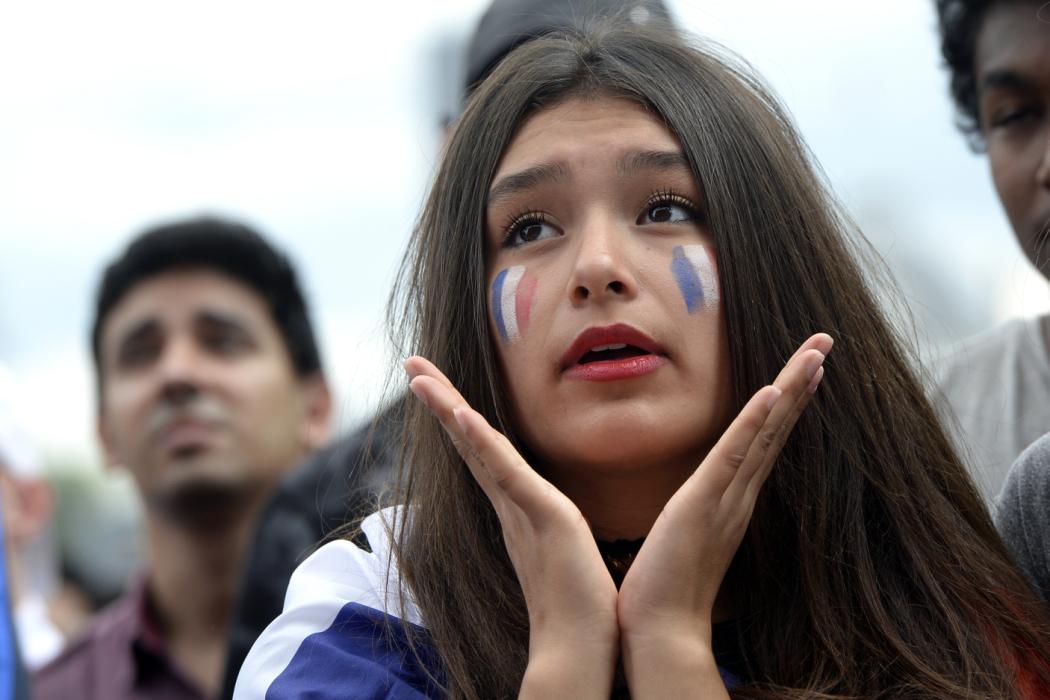 (FILES) This file photo taken on June 26, 2016 shows a France supporter reacting as she watches the Euro 2016 tournament round of 16 football match between France and Republic of Ireland at the Champ-de-Mars fan zone in Paris. A company of Aix-en-Provence created the "fanbrush", a multiple-line pencil for a make-up in the colours of France. / AFP PHOTO / ALAIN JOCARD