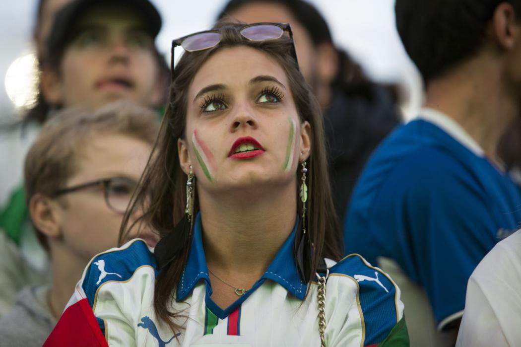 An Italia's supporter reacts as she watches on a giant screen in a fan zone the Euro 2016 quarter final football match between Italy and Germany on July 2, 2016, in Paris. / AFP PHOTO / GEOFFROY VAN DER HASSELT