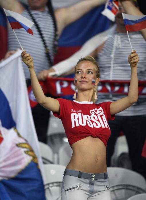 A Russia fan holds Russian flags as she waits for the start of the match before the Euro 2016 group B football match between Russia and Slovakia at the Pierre-Mauroy stadium in Villeneuve-d'Ascq, near Lille on June 15, 2016. / AFP PHOTO / MARTIN BUREAU