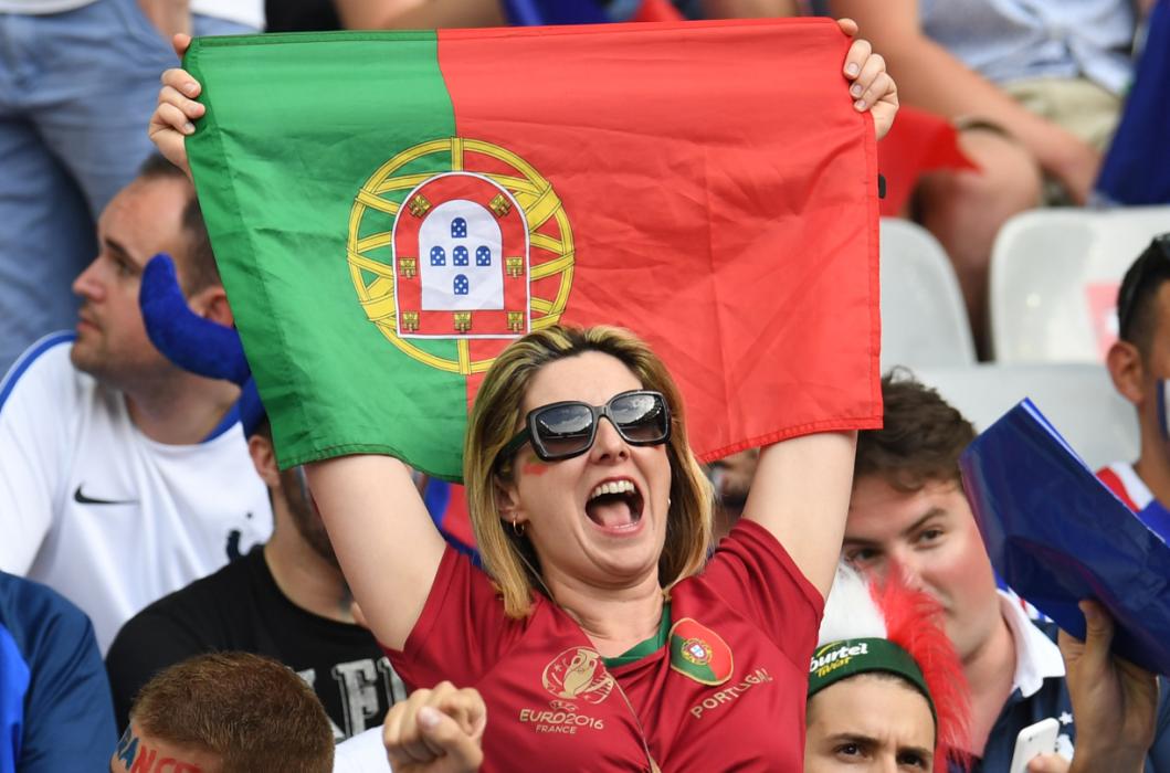 A Portugal supporter cheer ahead of the Euro 2016 final football match between Portugal and France at the Stade de France in Saint-Denis, north of Paris, on July 10, 2016. / AFP PHOTO / PATRIK STOLLARZ