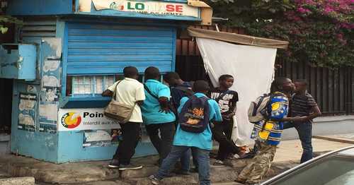 Des enfants joueurs de pari foot devant un kiosque de la Lonase: Honte à nous!