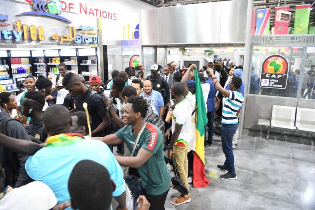 Can 2019: Les Lions bien arrivés en Égypte (photos) - Un groupe de personnes debout devant un magasin - Foule