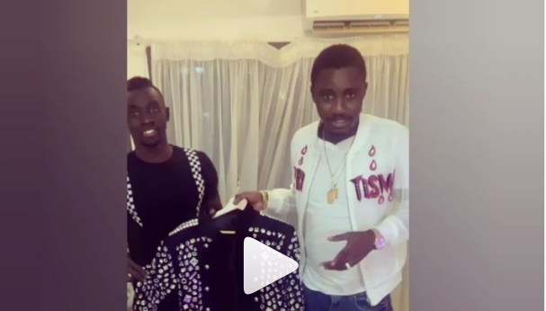 Papis Demba Cissé offre une veste bling bling à Wally Seck - Une personne qui pose pour la caméra - Conception
